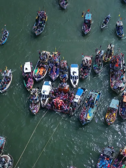 A closer top-down drone view of the flotilla of boats during the immersion. You can see the density of people who accompany the idol on its final journey into the sea.