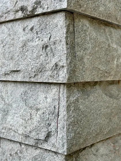 A detailed corner joint of the hand-chiseled stone, showing the precision of the craft.