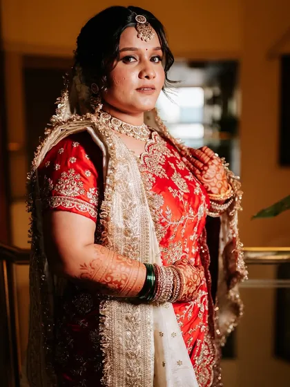 A full-length shot of the bride in her stunning red and white saree, ready for her big day.