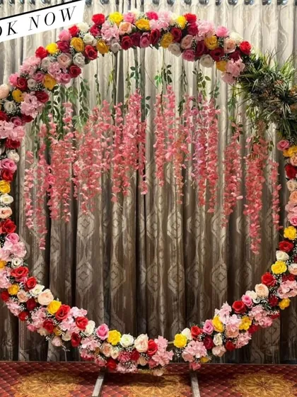 This full floral ring is bursting with color, featuring a mix of red, yellow, and pink roses. The hanging wisteria adds an extra layer of texture and beauty.