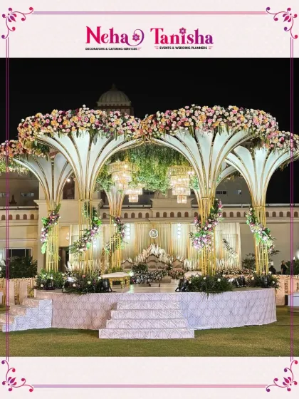 We believe your wedding stage should be nothing short of a masterpiece. This grand floral canopy, illuminated by elegant chandeliers, creates a breathtaking focal point for an unforgettable outdoor reception.
