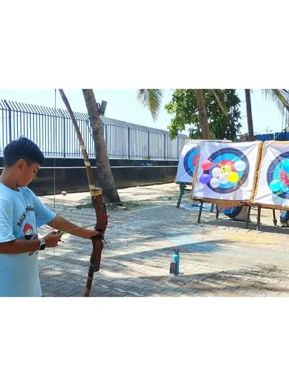 A young archer takes aim at the balloon-covered targets. It's a fun way to test the skills they've learned.