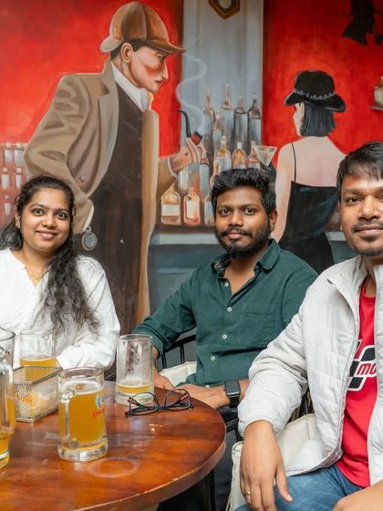 Friends enjoying beers and the unique Sherlock-themed mural.