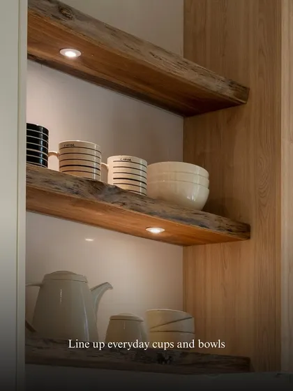 Lining up everyday cups and bowls on open shelves creates a sense of easy rhythm. The under-shelf lighting adds a warm glow, highlighting the simple beauty of your daily-use ceramics.