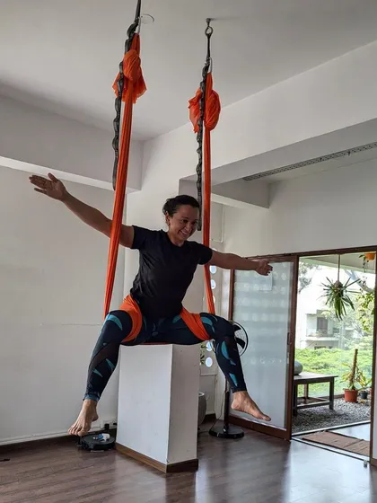 Spreading her wings. A student opens up into a wide-legged pose, embracing the space and support the aerial silk provides.