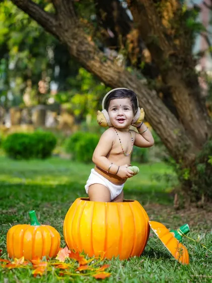 Our little pumpkin in a pumpkin patch. This outdoor setup is perfect for autumn, with a happy baby popping out of a giant pumpkin.