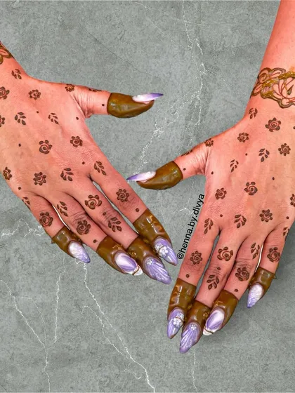 This scattered floral booti design is a favorite among guests. The small, delicate flowers give a sprinkle of tradition, while the lotus cuff adds a touch of elegance.