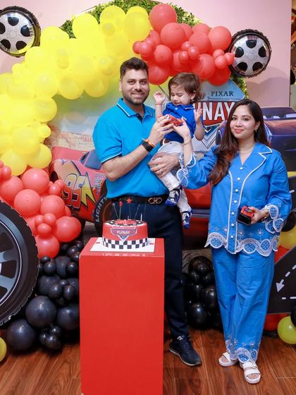 "Ka-chow!" A family celebrates their son's 2nd birthday with a high-octane Lightning McQueen theme, complete with a racetrack cake and a red, yellow, and black color scheme.