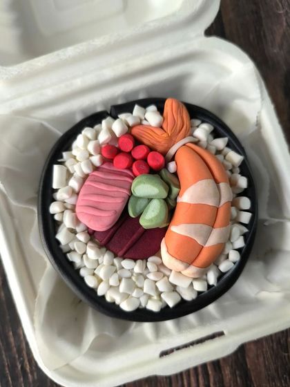 A cake that looks like a sushi platter. I used fondant to sculpt realistic-looking nigiri and rolls, making this a unique and surprising bento cake for any sushi enthusiast.