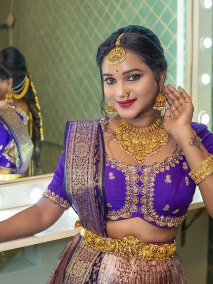 A shot of the model looking into a mirror, giving a glimpse of the back of the jewellery and the hairstyle.