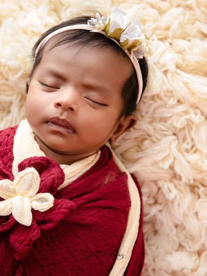 A beautiful two-tone wrap in red and cream with a floral knot detail, showing an advanced wrapping technique.