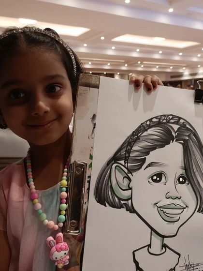 A sweet girl with her finished caricature. It's a lovely return gift idea for birthday parties.