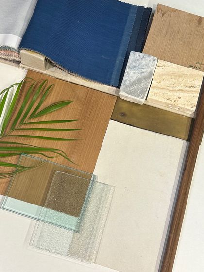 Another view of our material selections, featuring textured glass, wood veneers, and different types of stone. The palm leaf adds a touch of green, reminding us to always connect our spaces with nature.