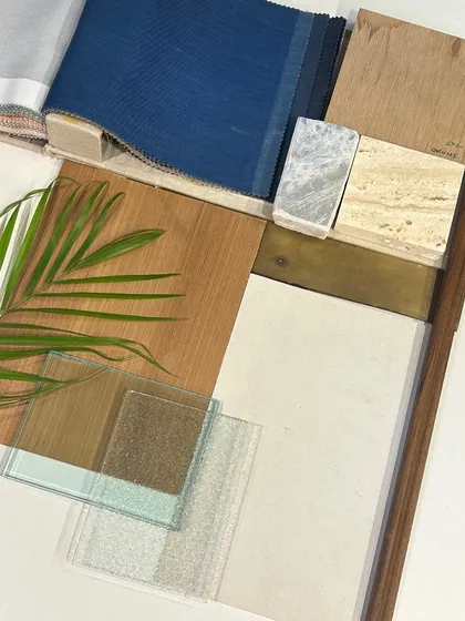 Another view of our material selections, featuring textured glass, wood veneers, and different types of stone. The palm leaf adds a touch of green, reminding us to always connect our spaces with nature.