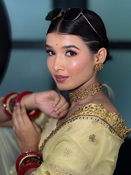 A playful and happy shot of the bride in the yellow saree, looking directly at the camera with a confident smile.