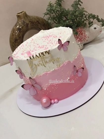 An angled view of the simple and elegant pink butterfly cake.
