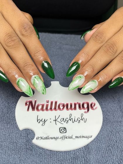 A rich, forest green set with accent nails featuring a beautiful green and white marble effect.