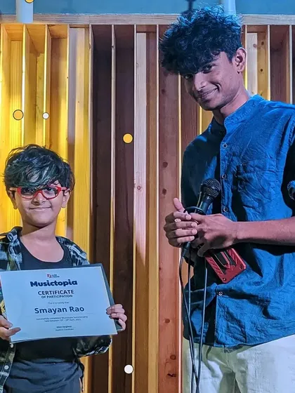 A proud student receives his Musictopia certificate of participation from a mentor. We celebrate every child's effort and progress.