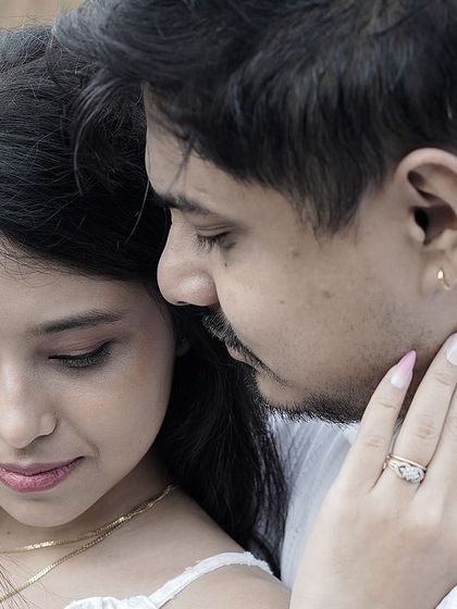 An intimate close-up of a couple, focusing on the bride's hand gently touching the groom's face.