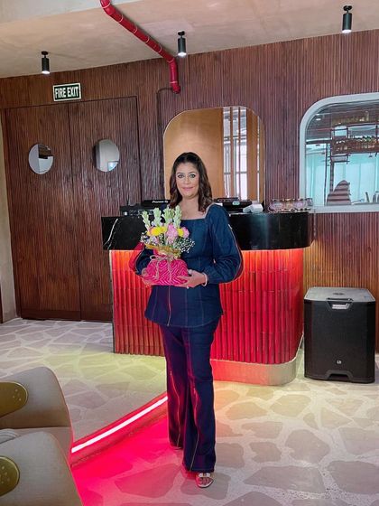Holding a beautiful floral arrangement created during one of our successful workshops. It's so rewarding to see participants leave with something they've made themselves.