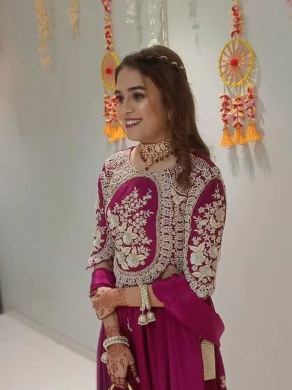 A happy client dressed for a festive occasion. She is wearing a beautiful Polki and red stone choker that perfectly complements her embroidered outfit.