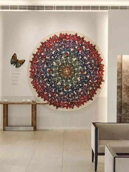 A stunning, colorful butterfly-themed carpet displayed as a central art piece in the Hands showroom. This highlights our approach of treating products as art, creating powerful focal points within the retail space.