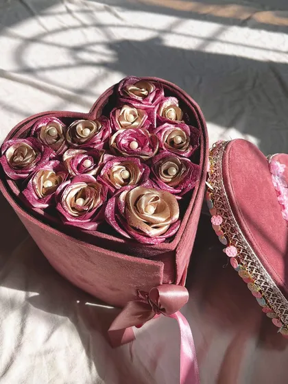 An overhead shot of the open heart box, showing the full arrangement of pink and gold satin roses. A perfect gift for a proposal, anniversary, or birthday.