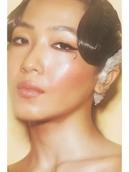 A warm, glowing beauty portrait of Patricia. The soft focus and golden tones create a dreamy and ethereal mood, highlighting the model's flawless skin.