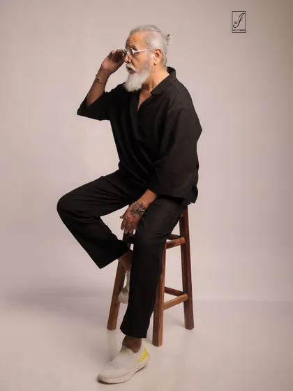 Adjusting his glasses, the model adds a touch of personality and intellect to this lifestyle portrait.