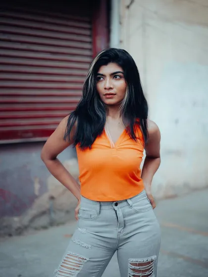 A full-length portrait of a model in a casual yet stylish outfit. The urban background and her confident pose make this a great street style shot.
