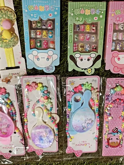 I also have fun items like kids' press on nail sticker sets. This photo shows them alongside other popular return gifts like the mirror and bead sets.