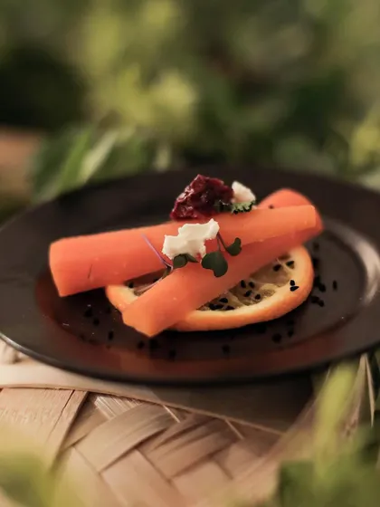 Another view of our slow cooked carrot dish, showcasing its elegant simplicity. The presentation on a dark plate makes the vibrant orange colour pop.