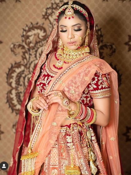 This bride looks stunning in a red and peach dual-tone lehenga. The heavy gold jewellery set she rented from us adds to the grandeur of the occasion.