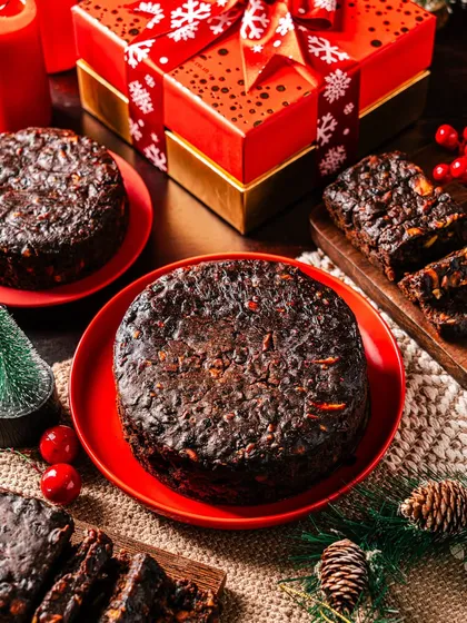 A rich, traditional Christmas plum cake, surrounded by festive decorations. My recipe is packed with soaked fruits and spices, making it a dense, flavorful, and essential part of any Christmas celebration.