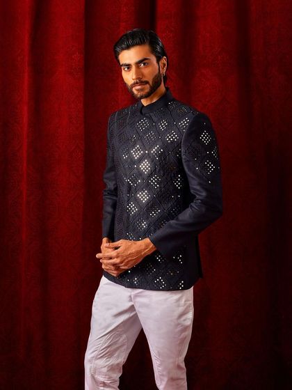 The full silhouette of our mirror work bandi jacket. Paired with white trousers, it creates a sharp, high-contrast look that is perfect for a festive evening party.