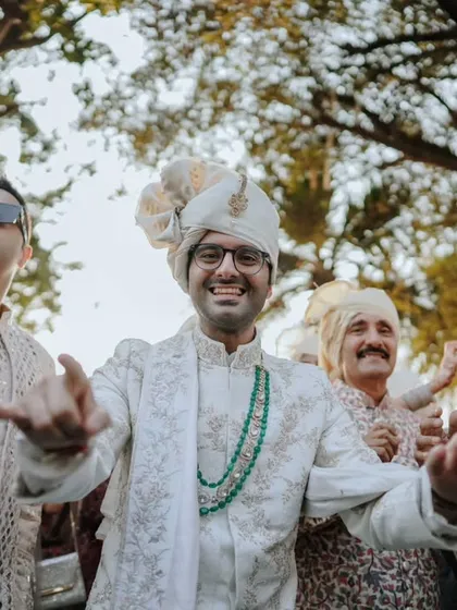The groom dances with his friends and family during the Baraat procession, a moment of pure joy and celebration.