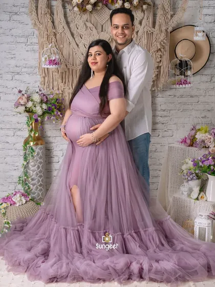 A full-length portrait of a couple in our boho-themed studio. The flowing lavender gown and casual attire of the partner create a lovely contrast.