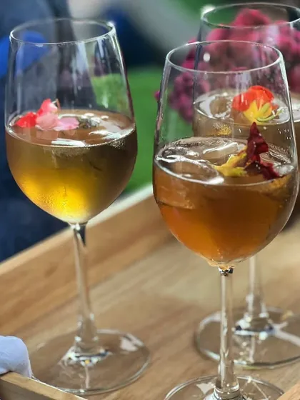 A tray of elegant welcome drinks, garnished with edible flowers, ready to be served to guests upon arrival.