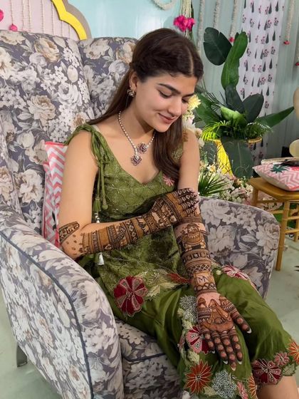 A bride admiring her intricate mehandi. We work closely with each bride to create a design that she will love and cherish.