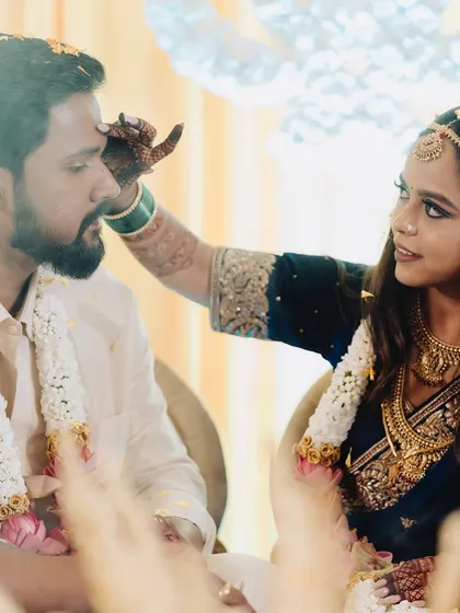 A beautiful moment from a traditional wedding ritual. The bride's makeup is elegant and respectful of the ceremony, with a focus on enhancing her natural beauty.