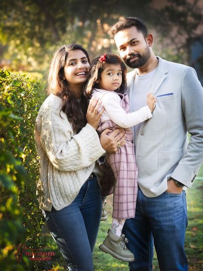 A classic family portrait taken during the golden hour in a beautiful park. The warm, natural light creates a soft and flattering look for everyone.