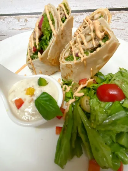 A delicious and convenient party snack. These are our Mexican-style wraps served with a side salad and a creamy dip, offering a complete and balanced bite.