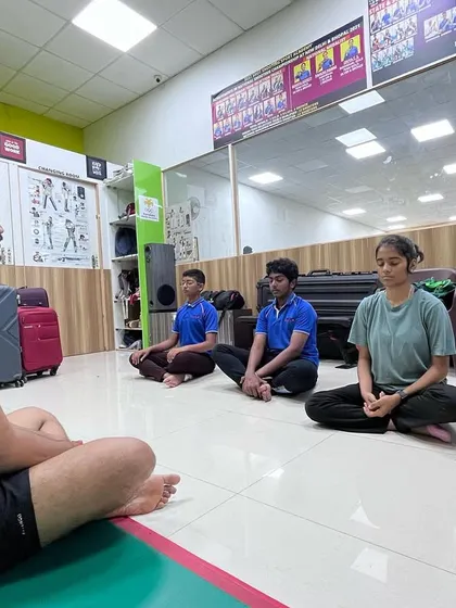 A coach leads a cool-down meditation session after practice. This helps our shooters relax their minds and bodies, reinforcing the connection between physical and mental training.