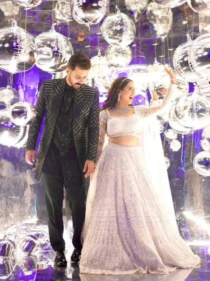 A beautiful couple shot against a backdrop of disco balls. Her glamorous cocktail makeup, with its sparkling eyes and radiant skin, fits the celebratory and grand atmosphere perfectly.