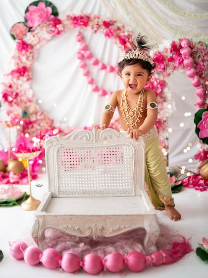 A happy little Krishna standing proudly next to his mini throne.
