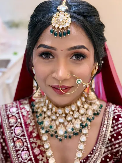 A close-up portrait showcasing the detailed makeup. The focus is on her bright eyes and the perfect base that enhances her skin.