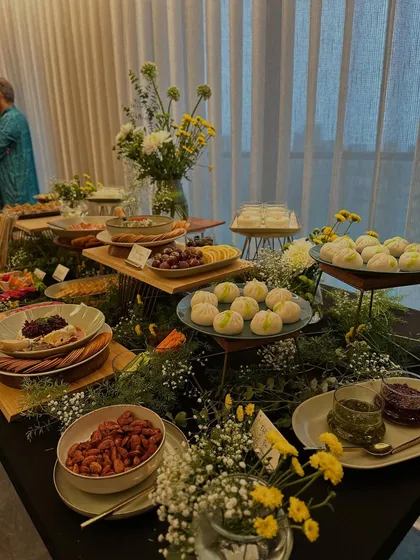 An elegant view of our festive grazing table, featuring beautifully arranged cheese platters, fruit, and desserts. The soft lighting and floral arrangements create a warm and inviting atmosphere.