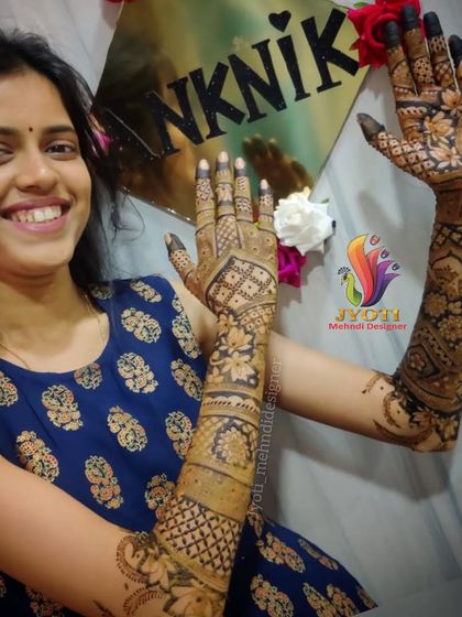 A happy bride showing off her full bridal mehndi. This is the result of many hours of work and collaboration to create a design that she loves.