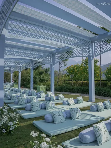 The low-level guest seating with custom-printed cushions in a delicate blue and green floral pattern, perfectly matching the event's color scheme.