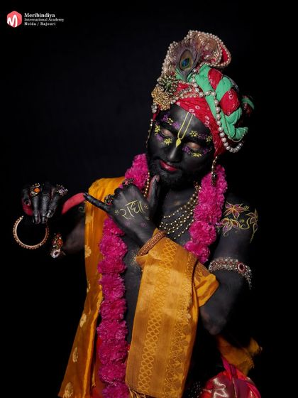 This look focuses on the transformation into Lord Krishna, using dark body paint, floral details, and traditional attire.